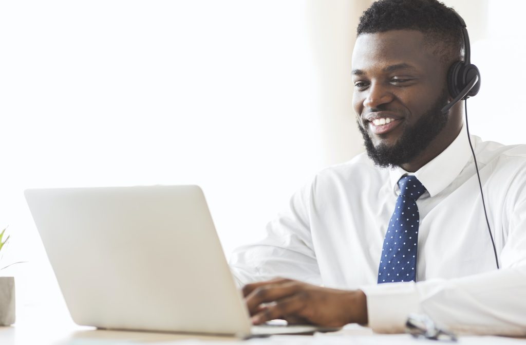 Young business consultant typing email to client on laptop